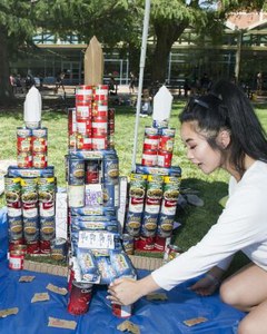 Student Jessica Truong makes adjustments to a castle of canned food that the Delta Epsilon Mu fraternity created in a fundraiser for The Pantry. (Jason Spyres/UC Davis photo)