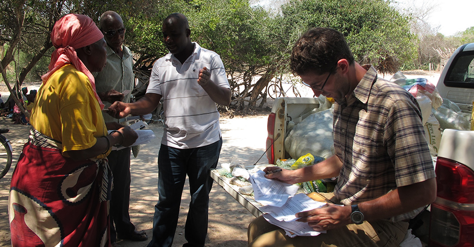 Jonathan Malacarne (right) reviews paperwork for seed and insurance purchases outside Chimoio in Mozambique. (AMA Innovation Lab)